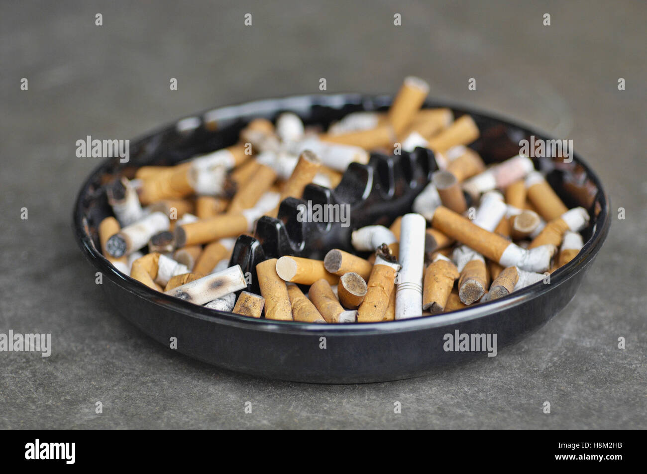 Posacenere completo di sigarette sul tavolo, close-up Foto Stock