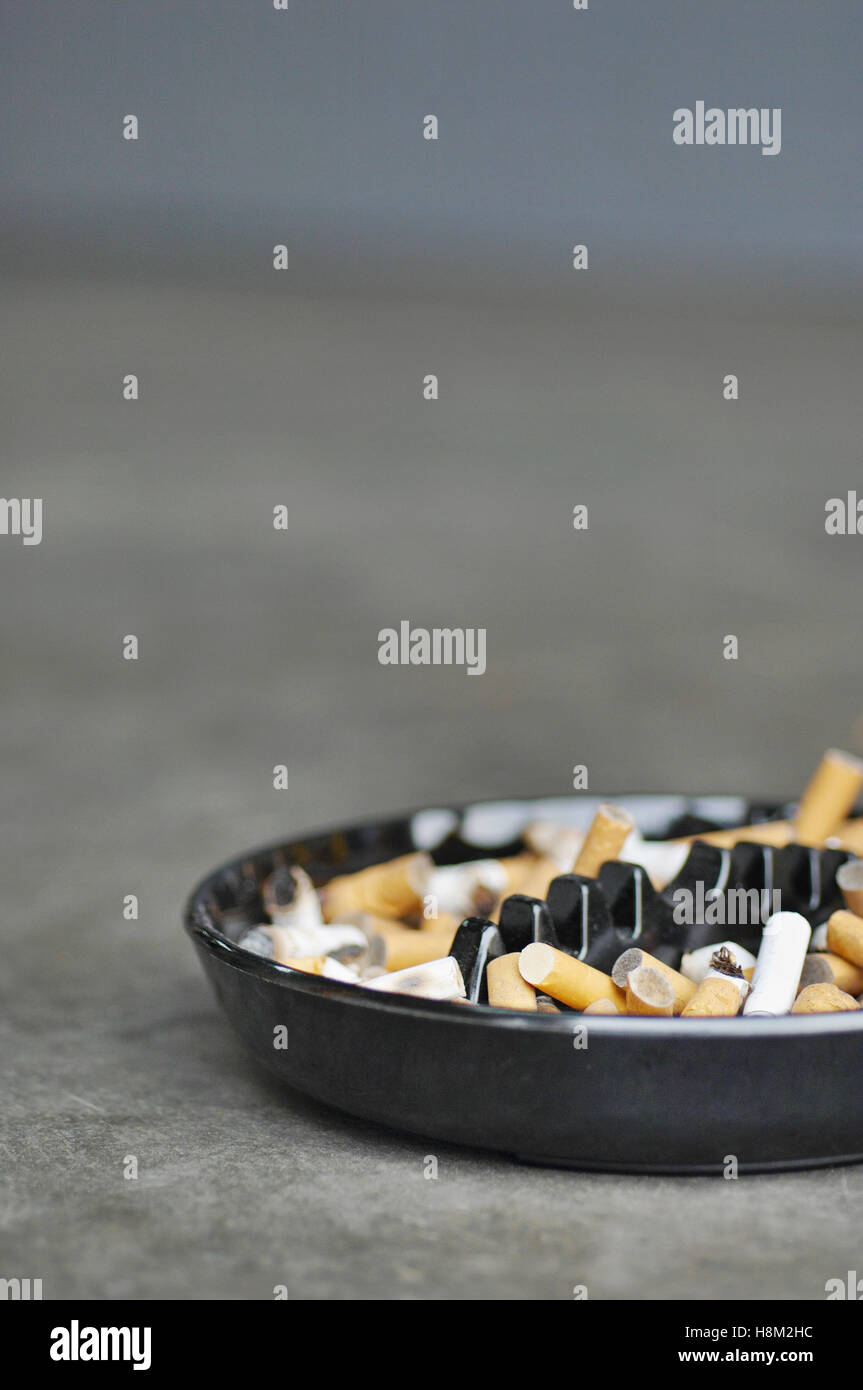 Posacenere completo di sigarette sul tavolo, close-up Foto Stock