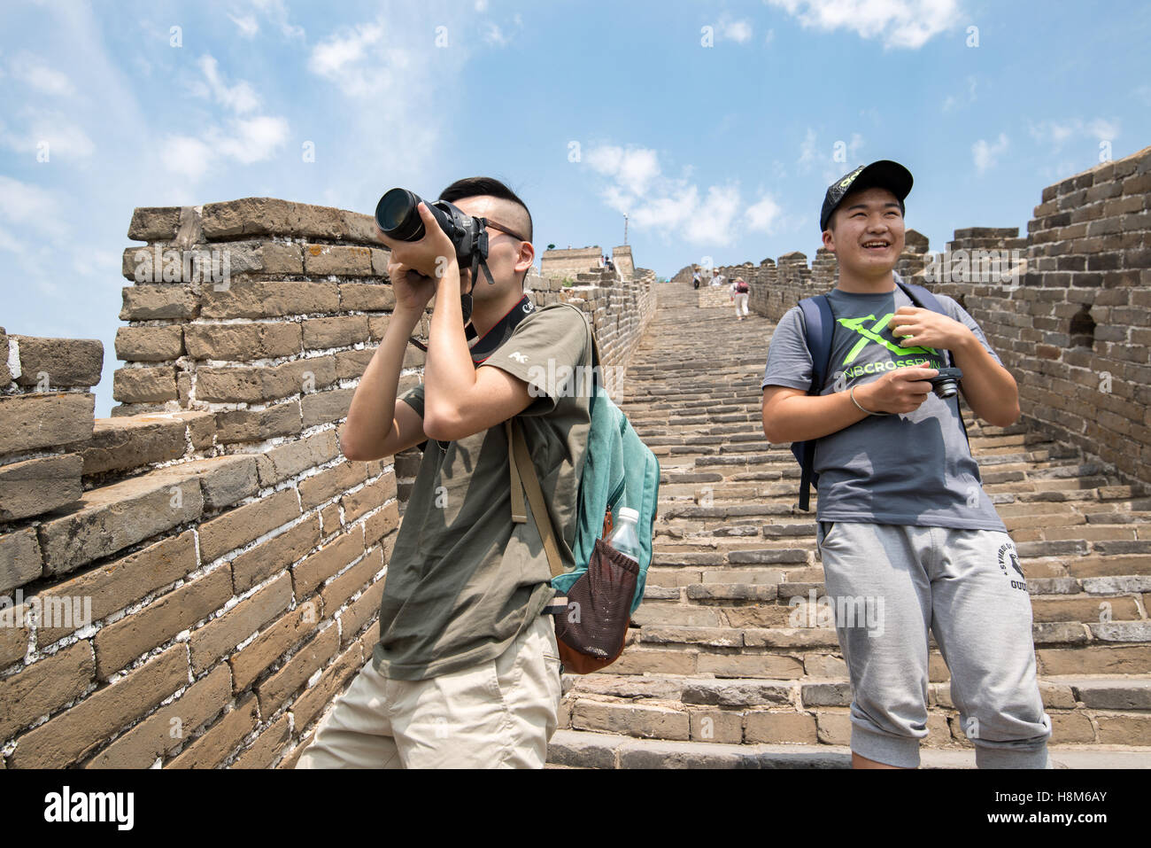 Mutianyu, Cina - vista ravvicinata di turisti fotografare e camminando sulla Grande Muraglia della Cina. La parete si estende per oltre 6,00 Foto Stock