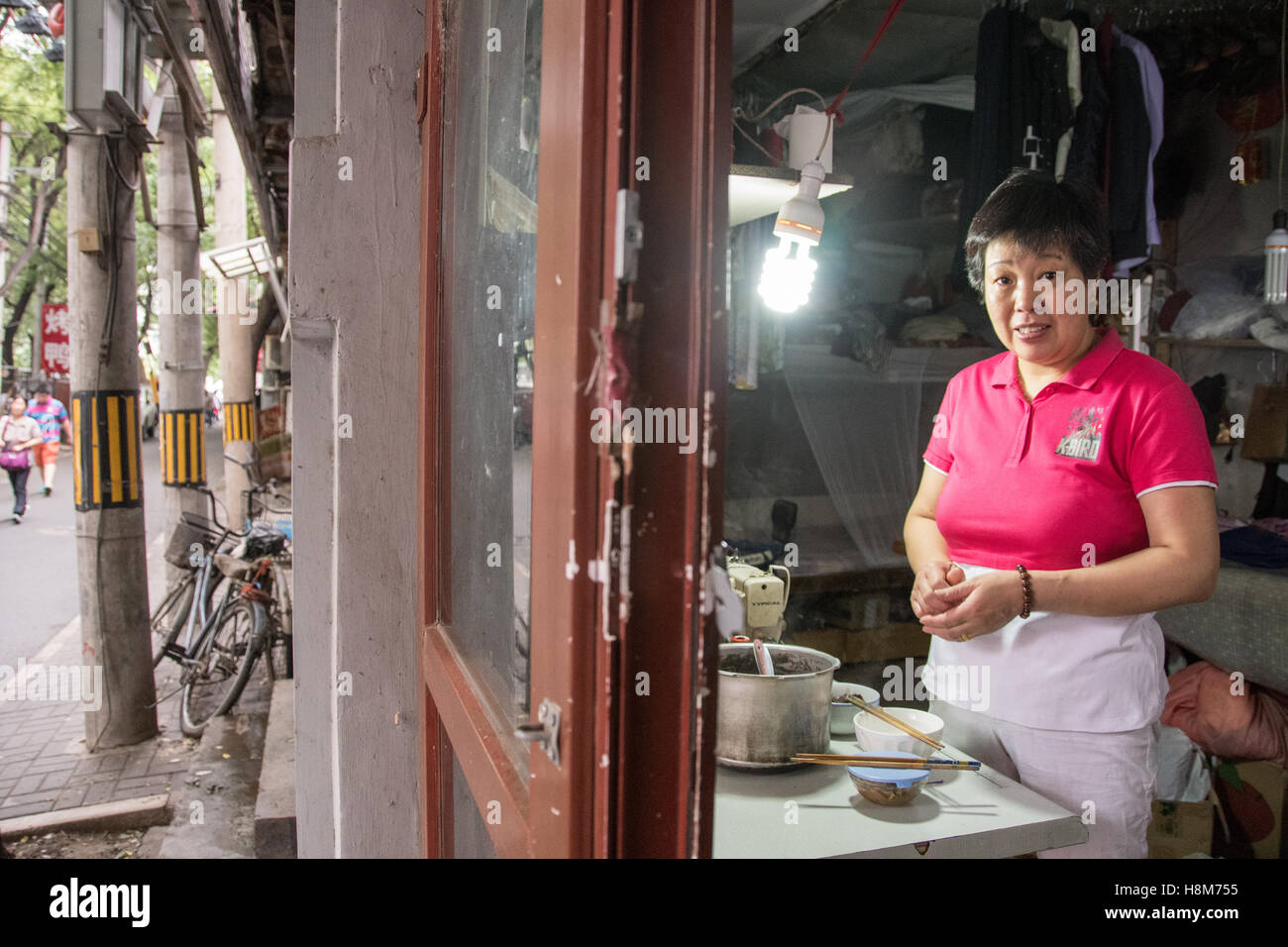 Pechino, Cina - la donna che fa il cibo di strada in un hutong situato nel centro di Pechino. Foto Stock