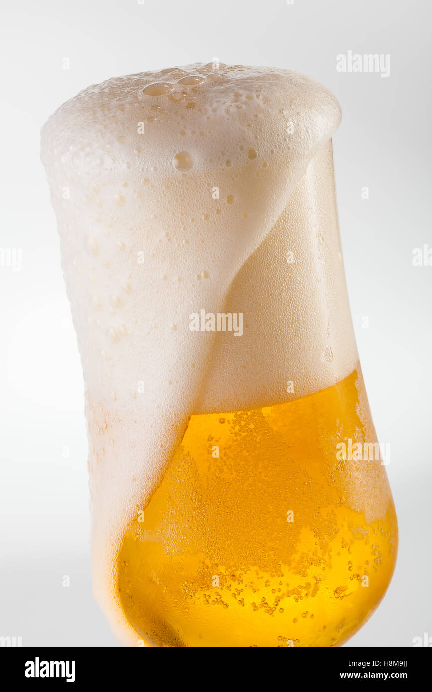 Traboccante di birra in un calice a tulipano Foto Stock