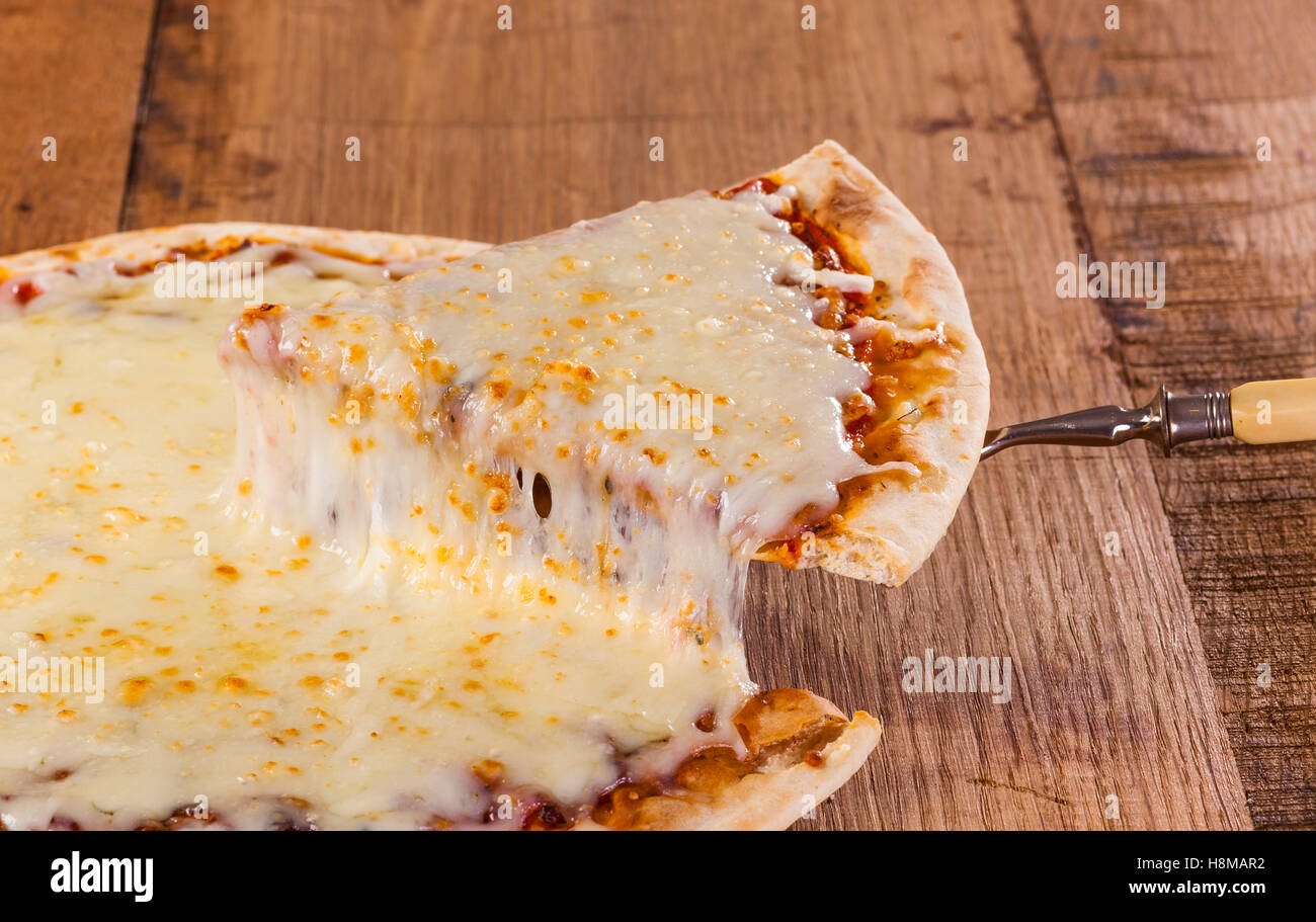 Sollevamento di un trancio di pizza caldo con il formaggio fuso Foto Stock