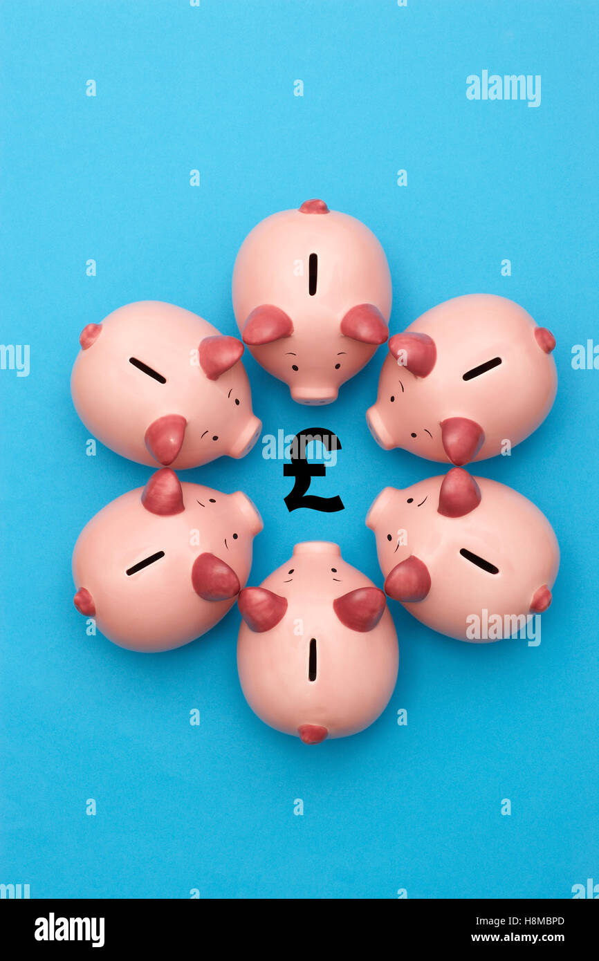 Salvadanaio di banche su sfondo blu che circonda un simbolo di GBP Foto Stock