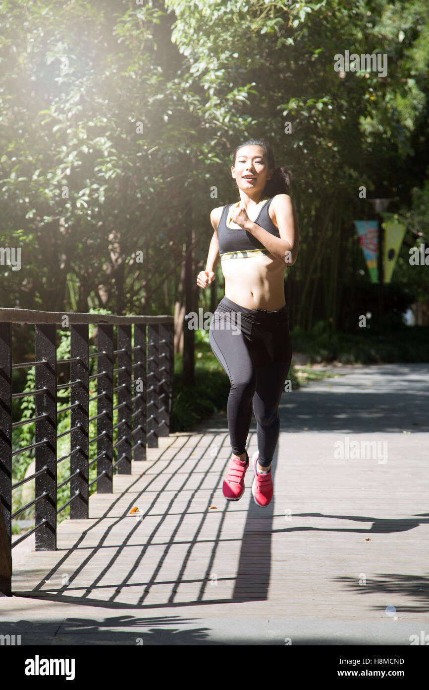 Montare e sano donna cinese in esecuzione in posizione di parcheggio Foto Stock