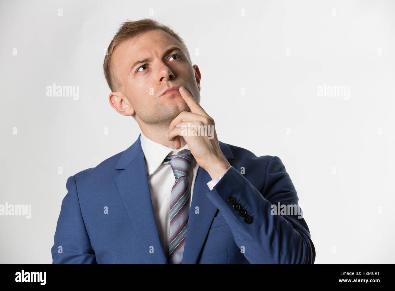 Imprenditore con il dito sulla faccia pensare Foto Stock