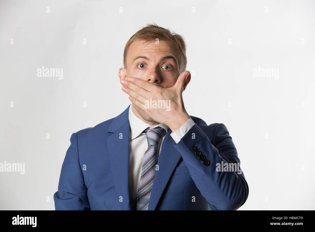 Scioccato imprenditore che copre la sua bocca Foto Stock
