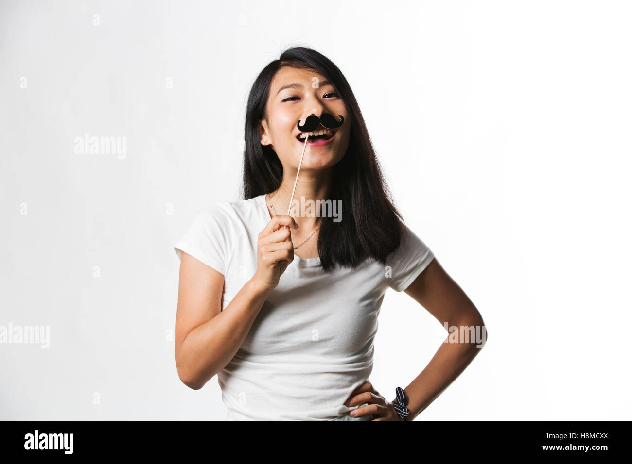 Donna cinese divertendosi con un baffi finti Foto Stock