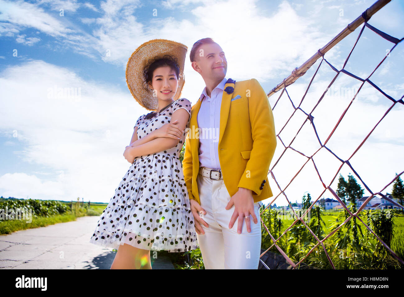 Ritratto di donna fiducioso in piedi con l'uomo sul campo contro sky Foto Stock