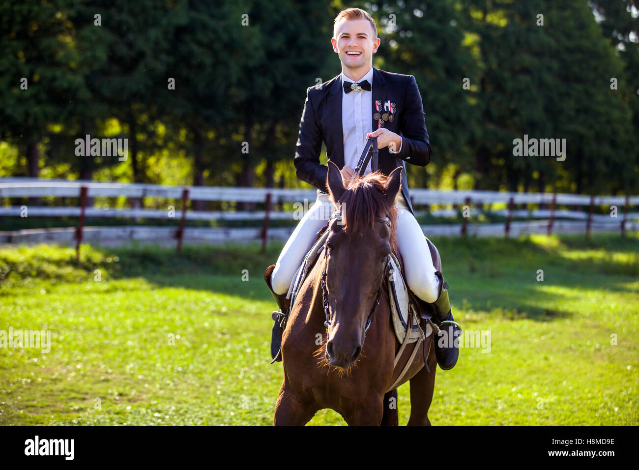 Ritratto di uomo felice di equitazione su campo Foto Stock