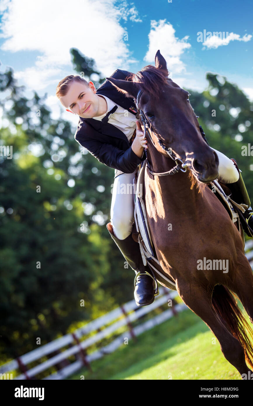 Ritratto di fiducioso uomo a cavallo sul campo Foto Stock
