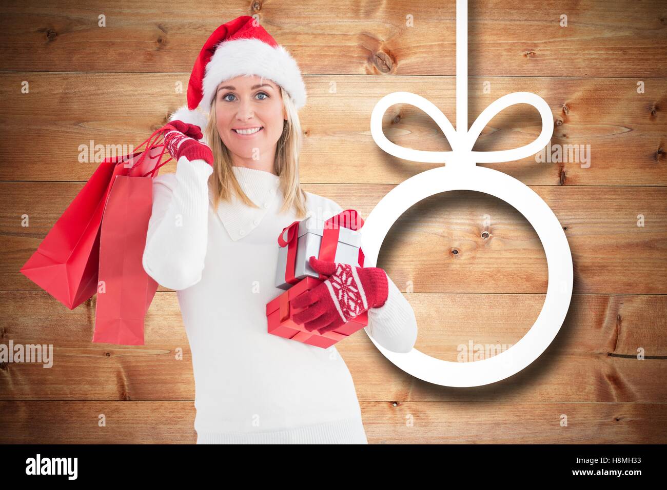 Donna sorridente in santa hat holding regali di natale e di borse per lo shopping Foto Stock