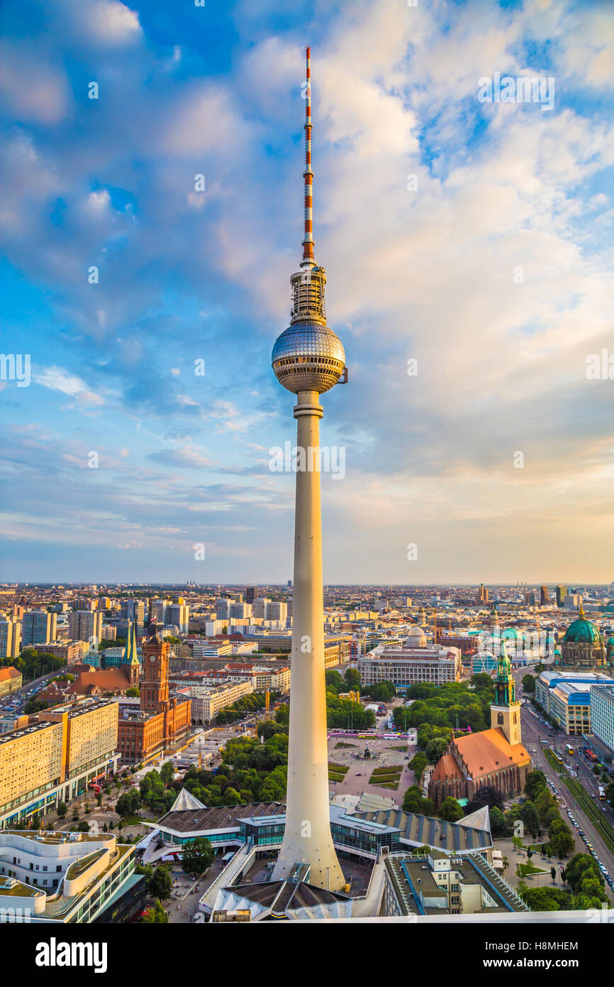 Antenna ad ampio angolo di vista sullo skyline di Berlino con la famosa torre della TV ad Alexanderplatz e nuvole drammatico in una bellissima serata d'oro al tramonto, Germania Foto Stock