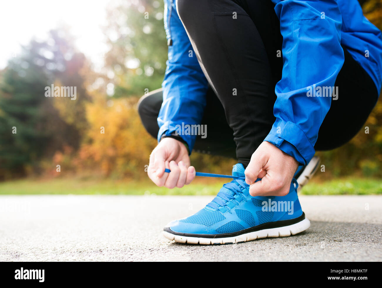 Irriconoscibile runner accovacciato, legatura lacci delle scarpe, close up Foto Stock