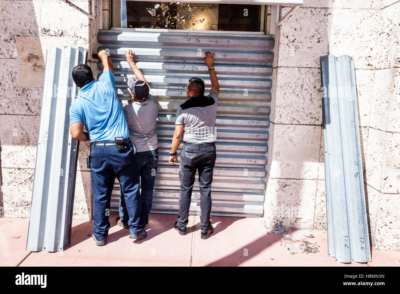 Miami Beach Florida, Collins Avenue, preparazione, installazione persiane, uragano Matteo, ispanico adulto, adulti, uomo uomo maschio, FL161025016 Foto Stock