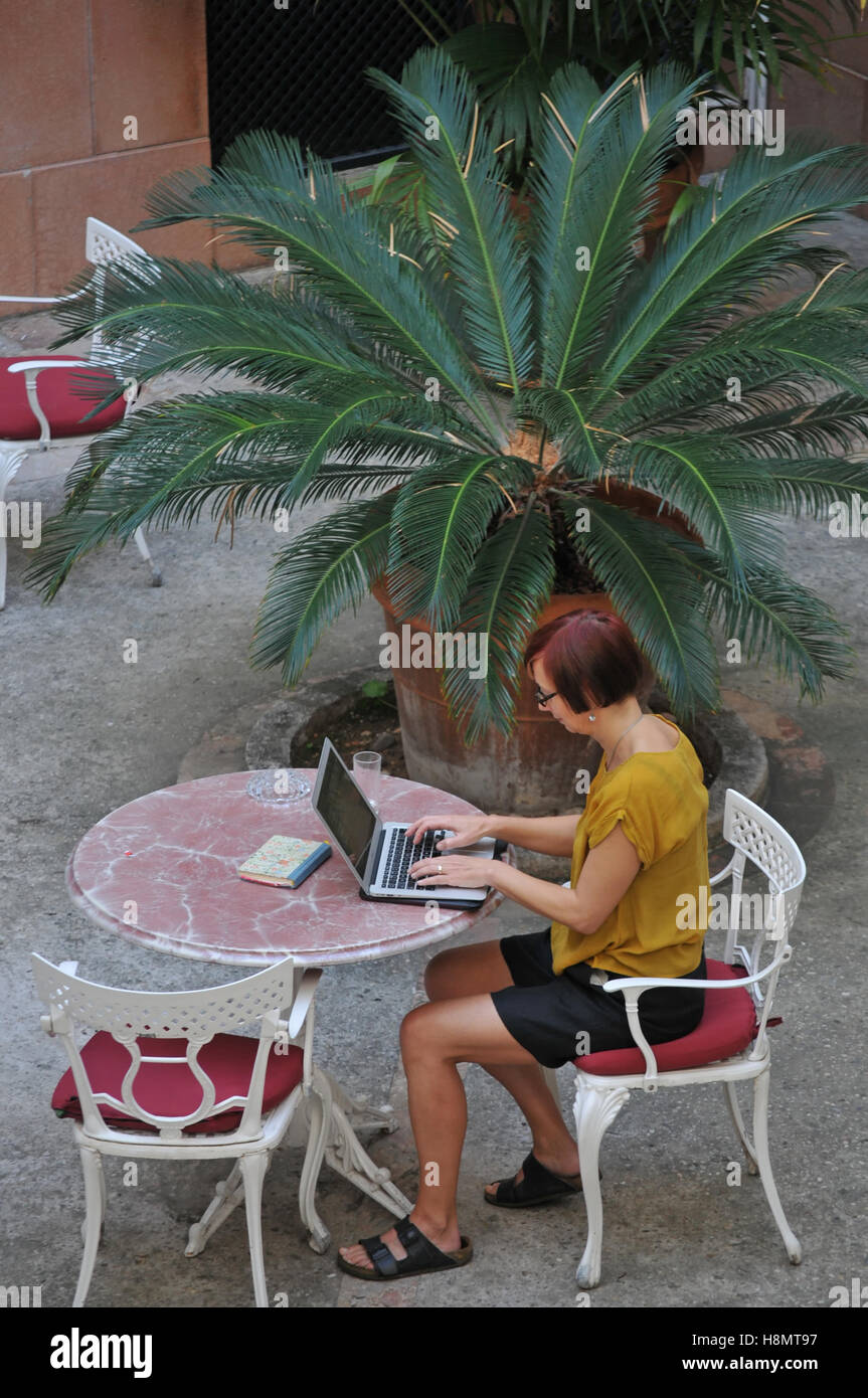 Una donna che lavora in un giardino di hotel in Palma di Maiorca Foto Stock