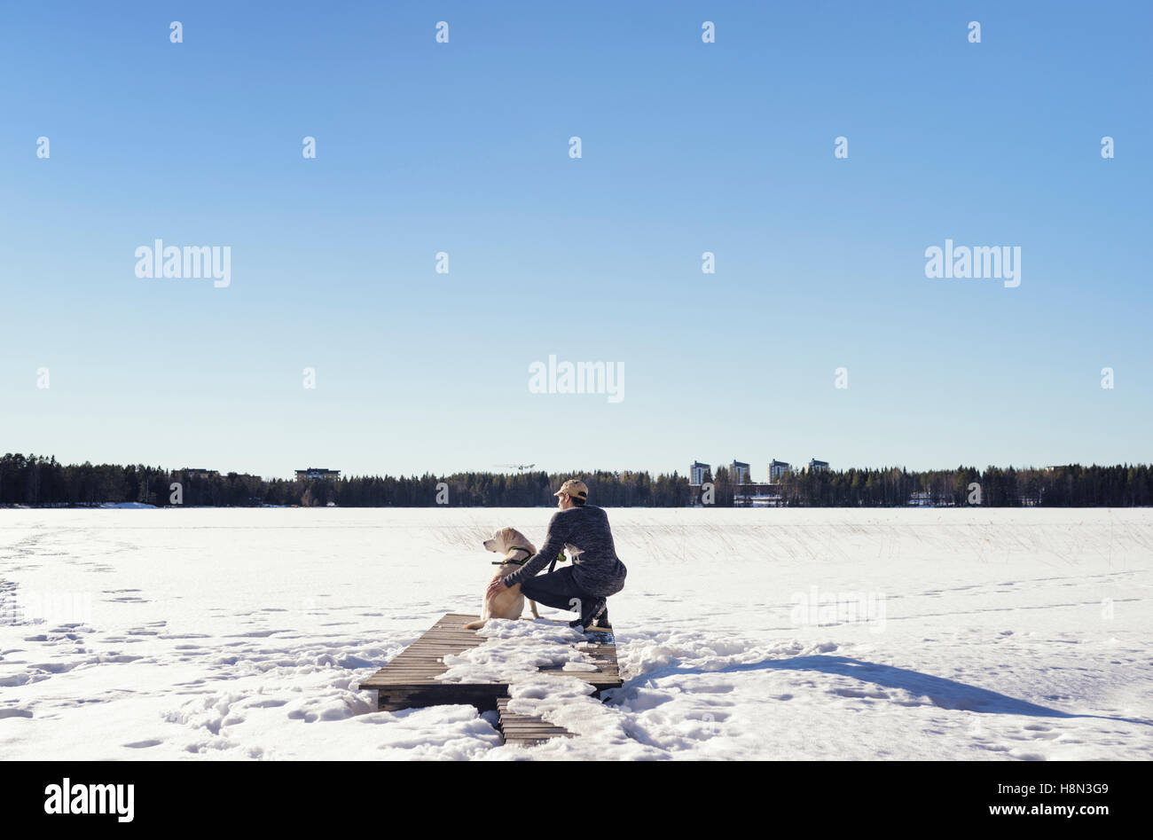 Uomo con cane guardando il paesaggio invernale Foto Stock