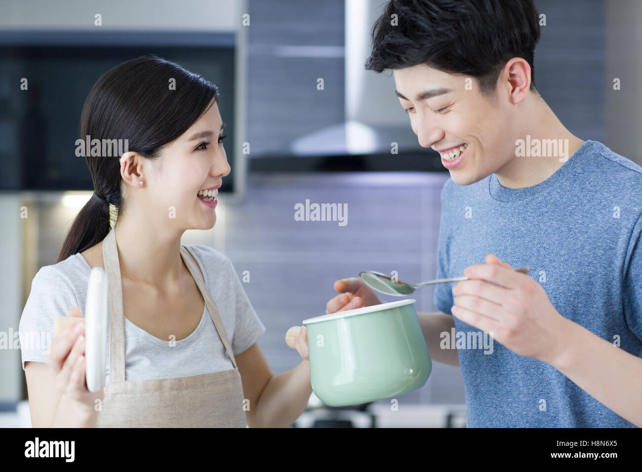 Felice giovani cinesi matura per la cottura in cucina Foto Stock