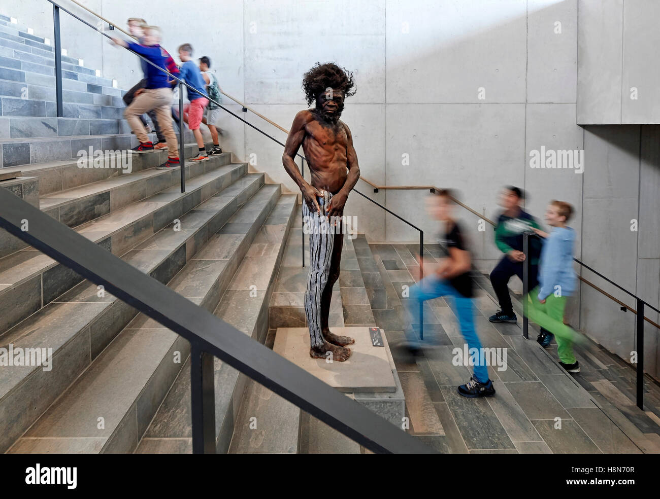 Dettaglio di Età della Pietra uomo replica e visitatori. Moesgaard Museum, Aarhus, Danimarca. Architetto: Henning Larsen, 2015. Foto Stock