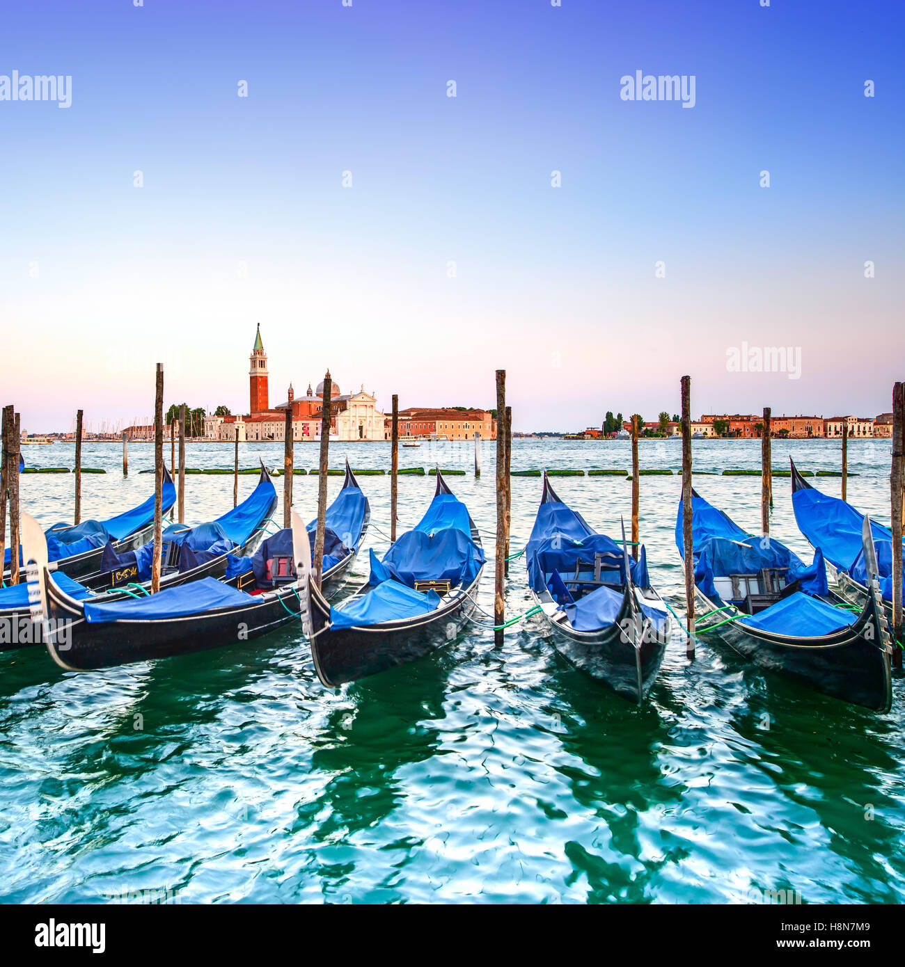 Venezia tramonto, gondole o gondole su un cielo blu e la chiesa di San Giorgio Maggiore punto di riferimento sullo sfondo. L'Italia, l'Europa. Foto Stock