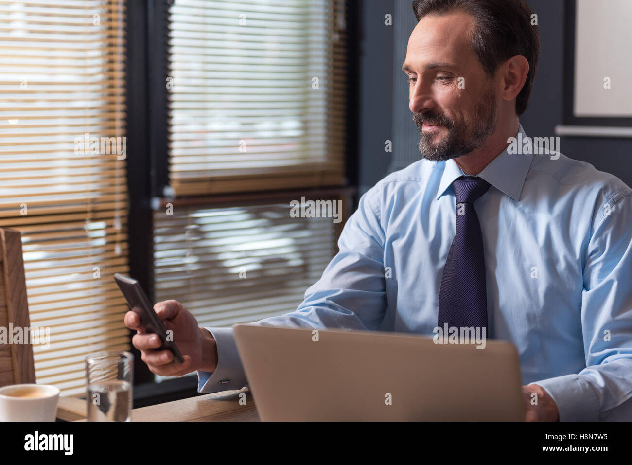 Allegro buon imprenditore cerca di effettuare una chiamata Foto Stock