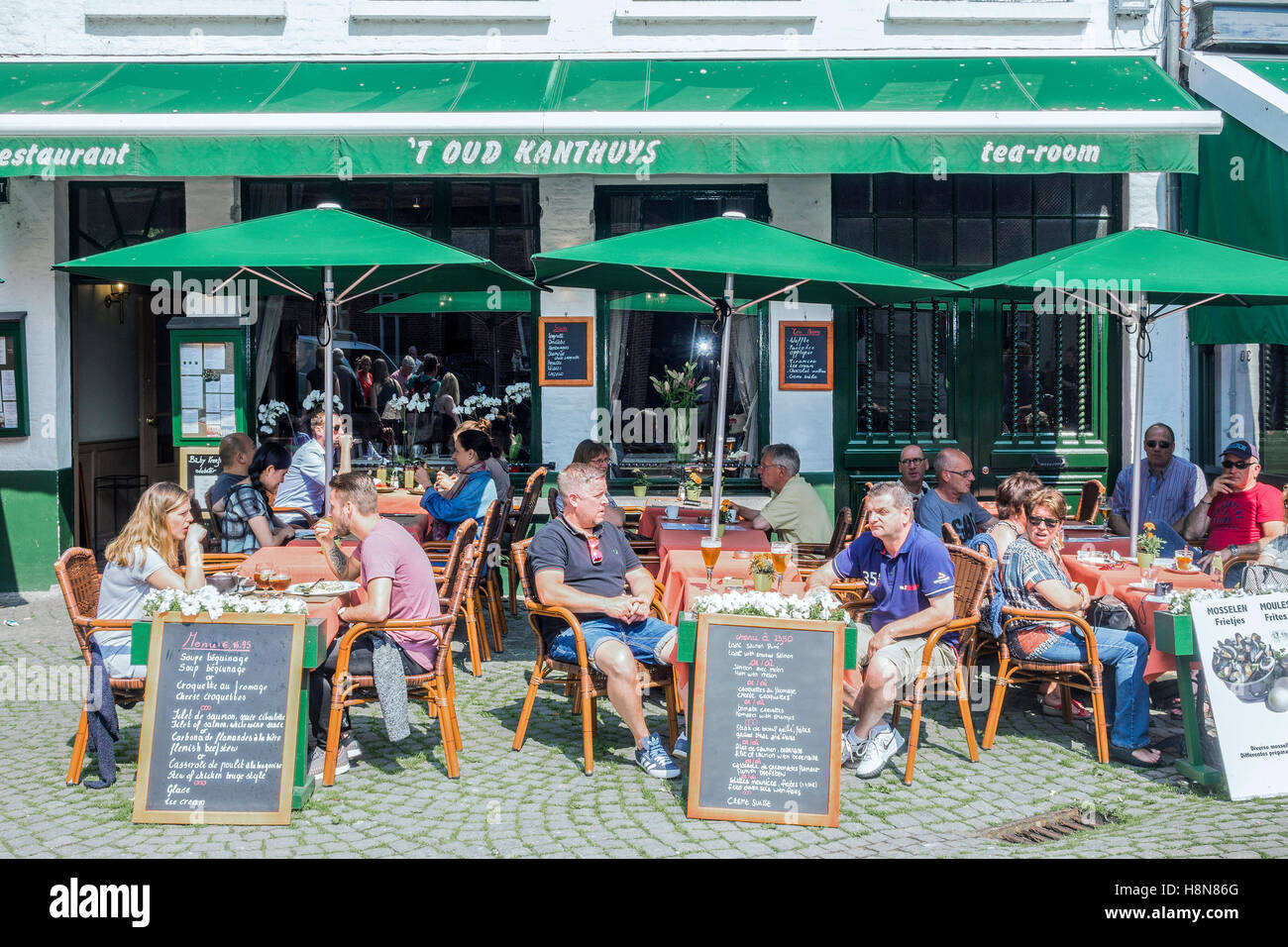 Persone rilassarsi davanti a un drink Bruges Belgio Foto Stock