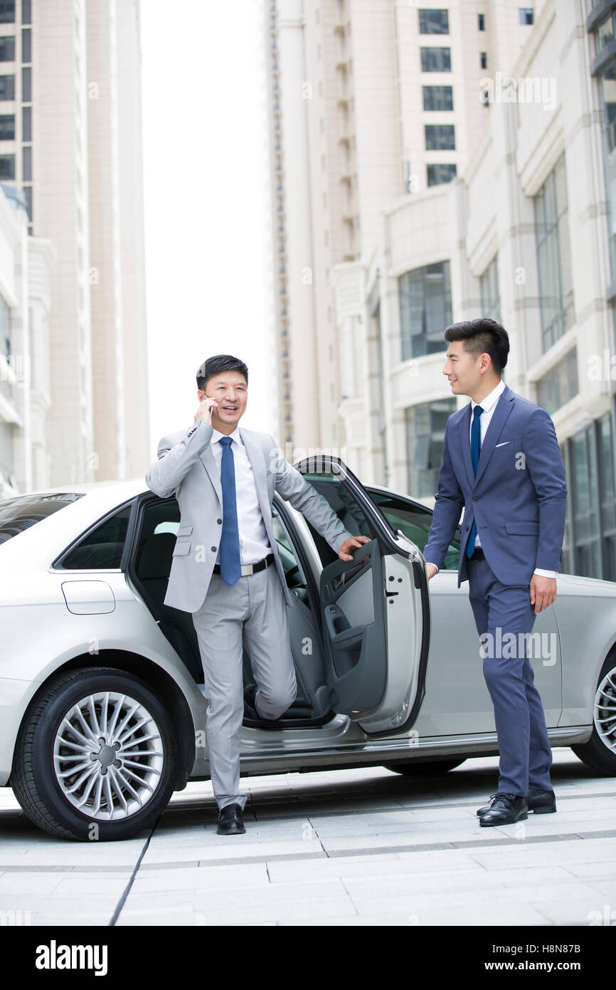 Fiducioso imprenditore cinese getting off auto Foto Stock