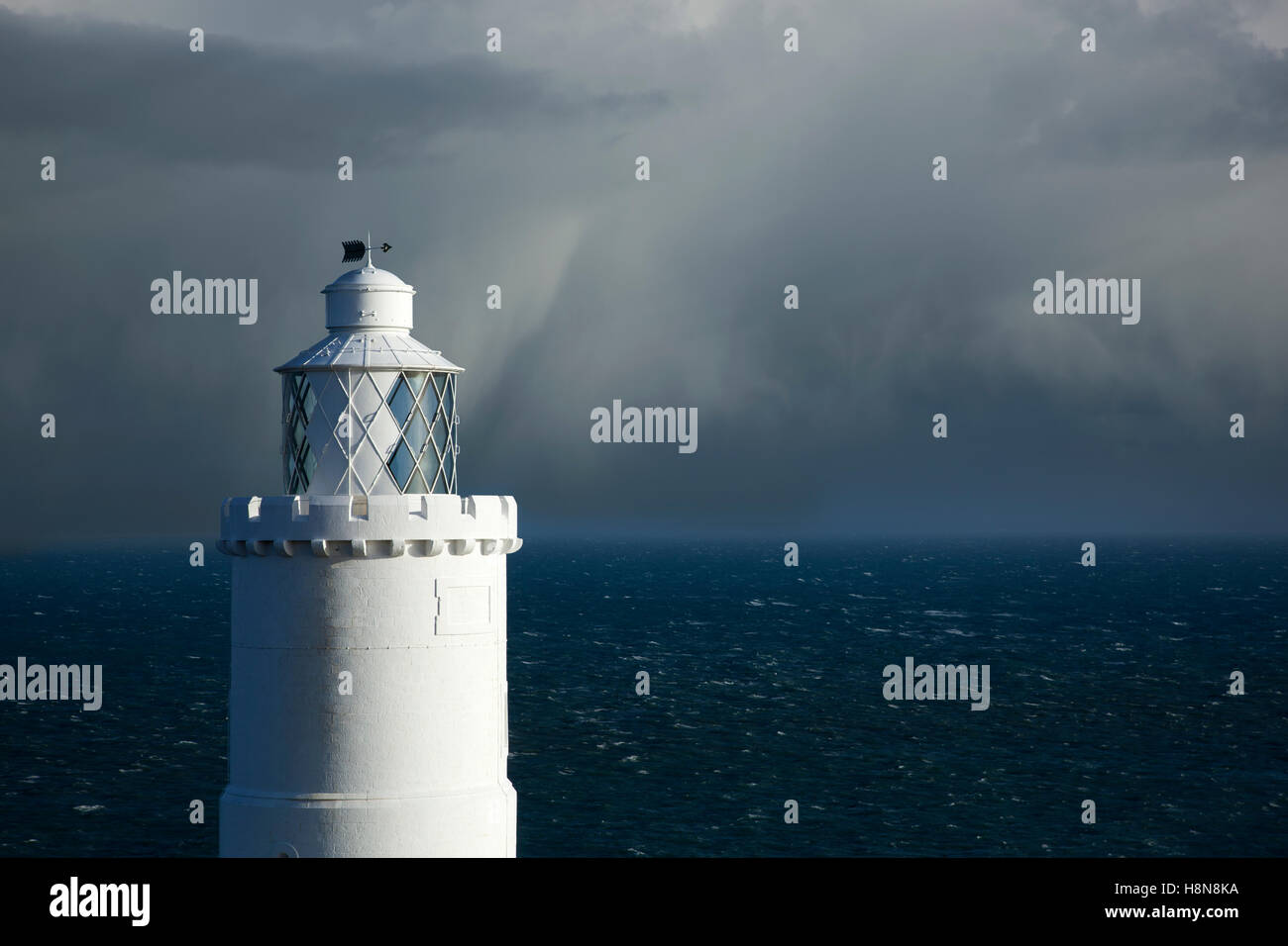 Faro sulla costa con storm avvicinandosi al punto di partenza,Devon, Inghilterra Foto Stock