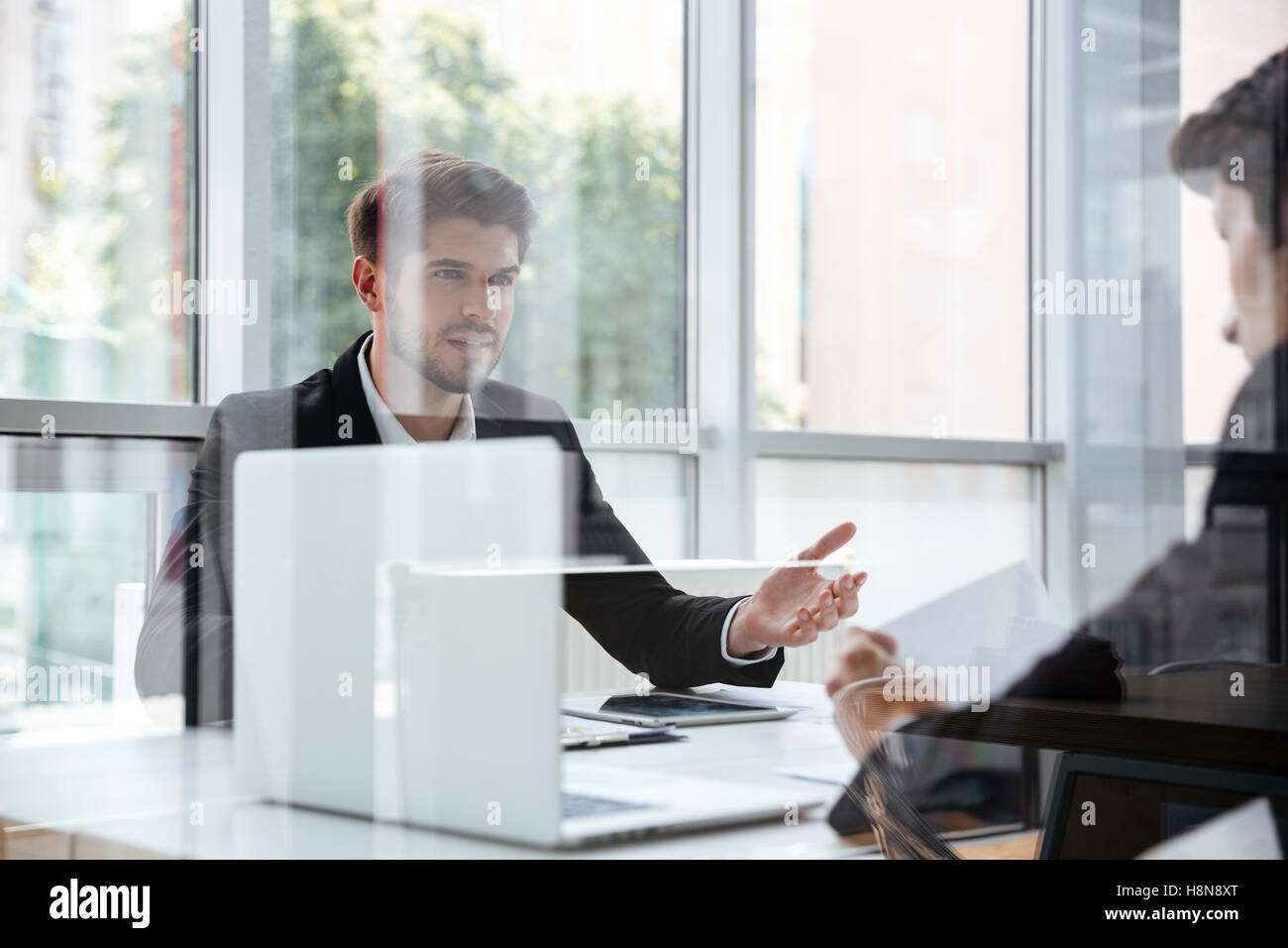 Due bello i giovani imprenditori con il computer portatile sulla riunione di affari Foto Stock