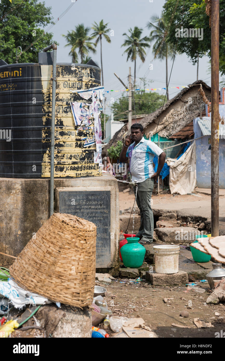 Uomo Tamil punps acqua fuori del serbatoio nero in Dindigul. Foto Stock