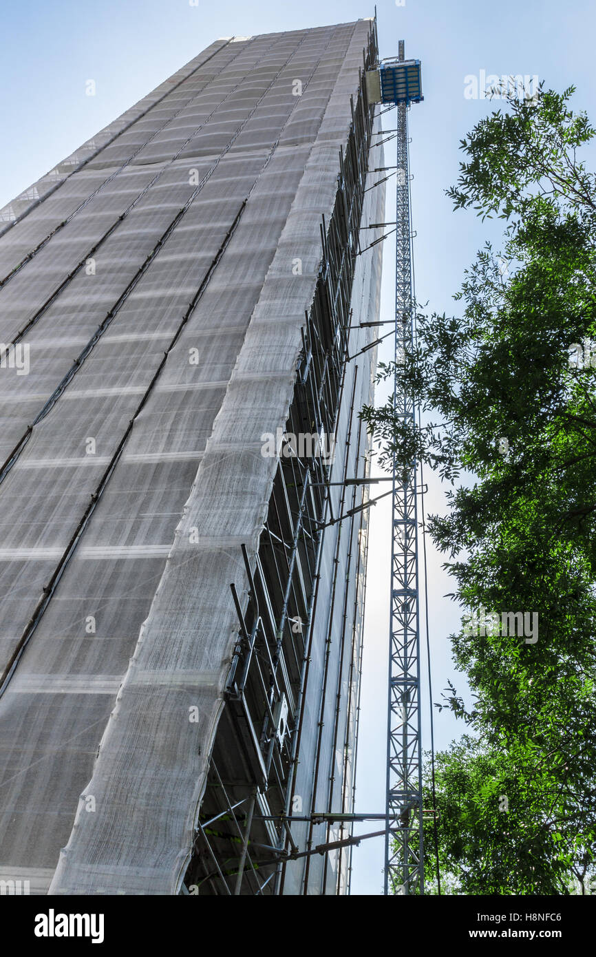 Alta ponteggio in cantiere con paranco di sollevamento Foto Stock