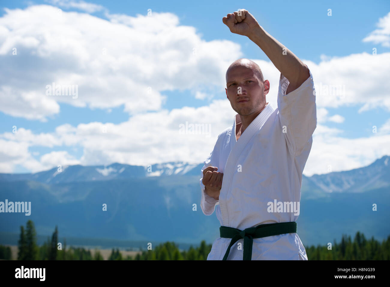 Uomo in bianco kimono e Allenamento cinture nere kung-fu, karate o aikido  su sfondo di montagna Foto stock - Alamy