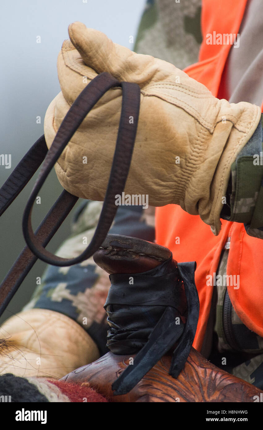 Equitazione l uomo con la mano sulla sella avvisatore acustico Foto Stock