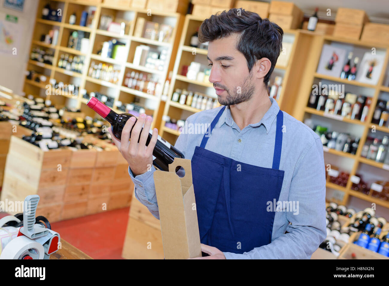 Commerciante di vino che controlla l'etichetta di una bottiglia Foto Stock