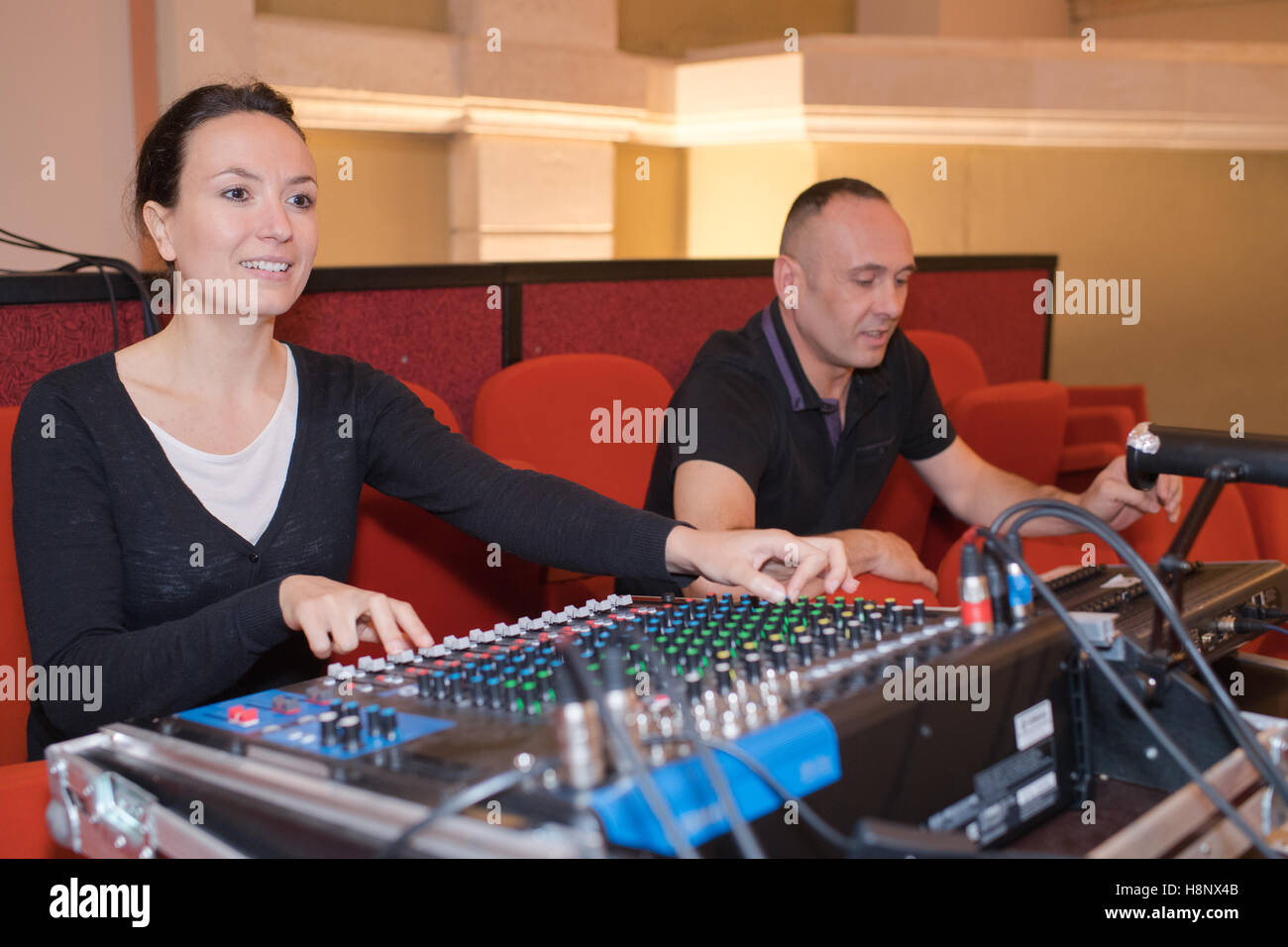 Ingegnere del suono e produttore lavorando insieme al pannello di miscelazione Foto Stock
