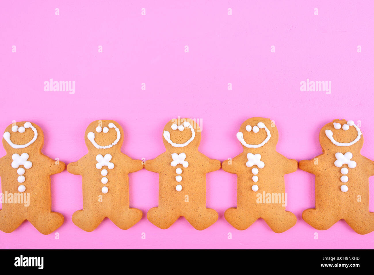 Festive moderno tema rosa vacanze di Natale sfondo con gingerbread cookies sul legno di rosa tabella. Foto Stock
