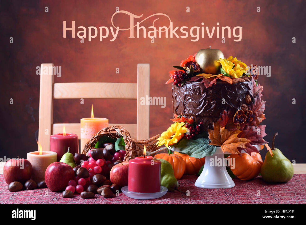 Bella caduta del Ringraziamento impostazione tabella con autunno tema torta al cioccolato, cornucopia e candele. Foto Stock