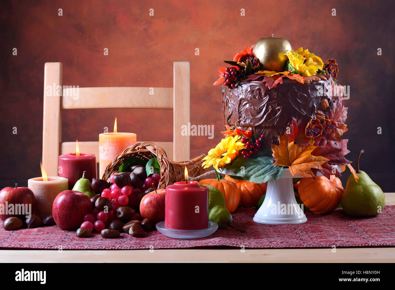 Bella caduta del Ringraziamento impostazione tabella con autunno tema torta al cioccolato, cornucopia e candele. Foto Stock