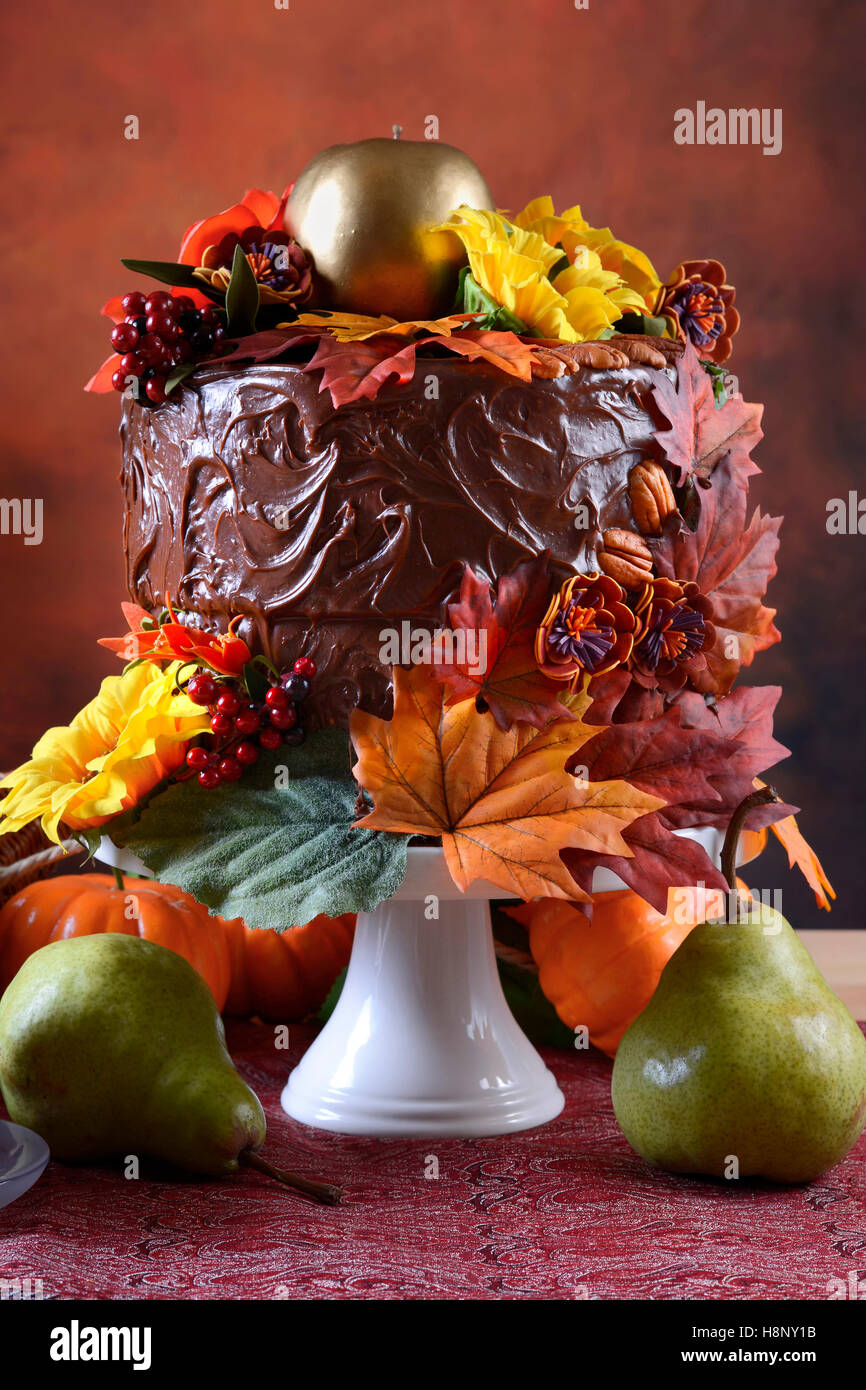 Bella caduta del Ringraziamento impostazione tabella con autunno tema torta al cioccolato, cornucopia e candele, primo piano. Foto Stock