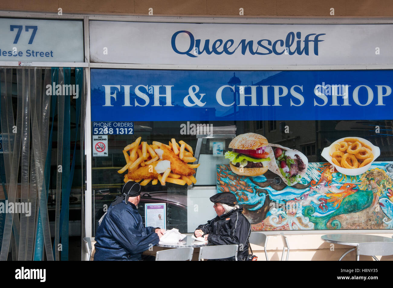 Coppia di anziani di mangiare al di fuori di una vecchia pesce e patatine shop in queenscliff, victoria Foto Stock