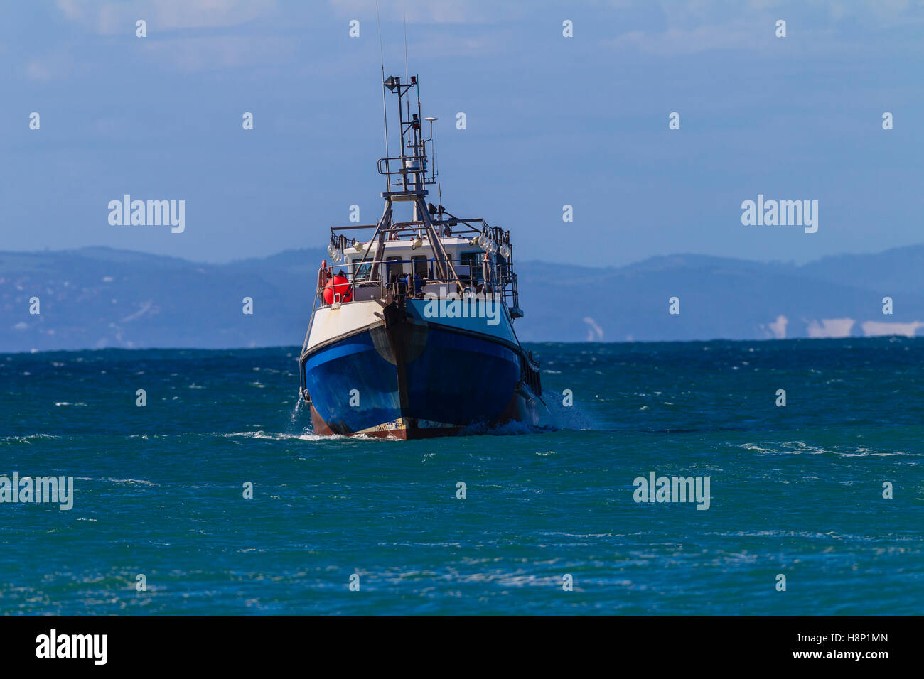 Barca da pesca a strascico vicino alla costa all'interno di alloggiamento per un oceano di protezione storm Foto Stock