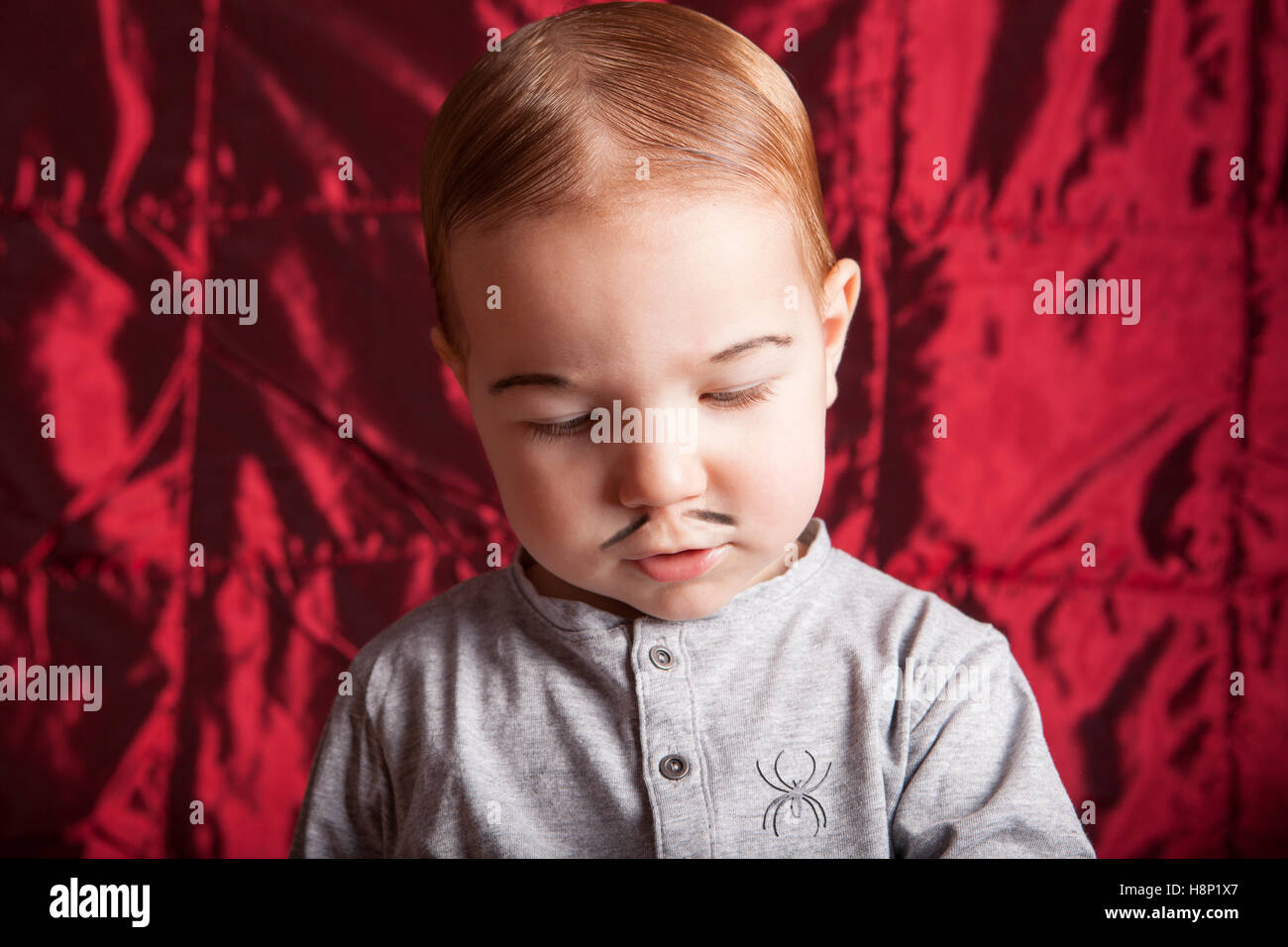 Ritratto di un ragazzino dress up per la festa di Halloween. Raso rosso sfondo Foto Stock
