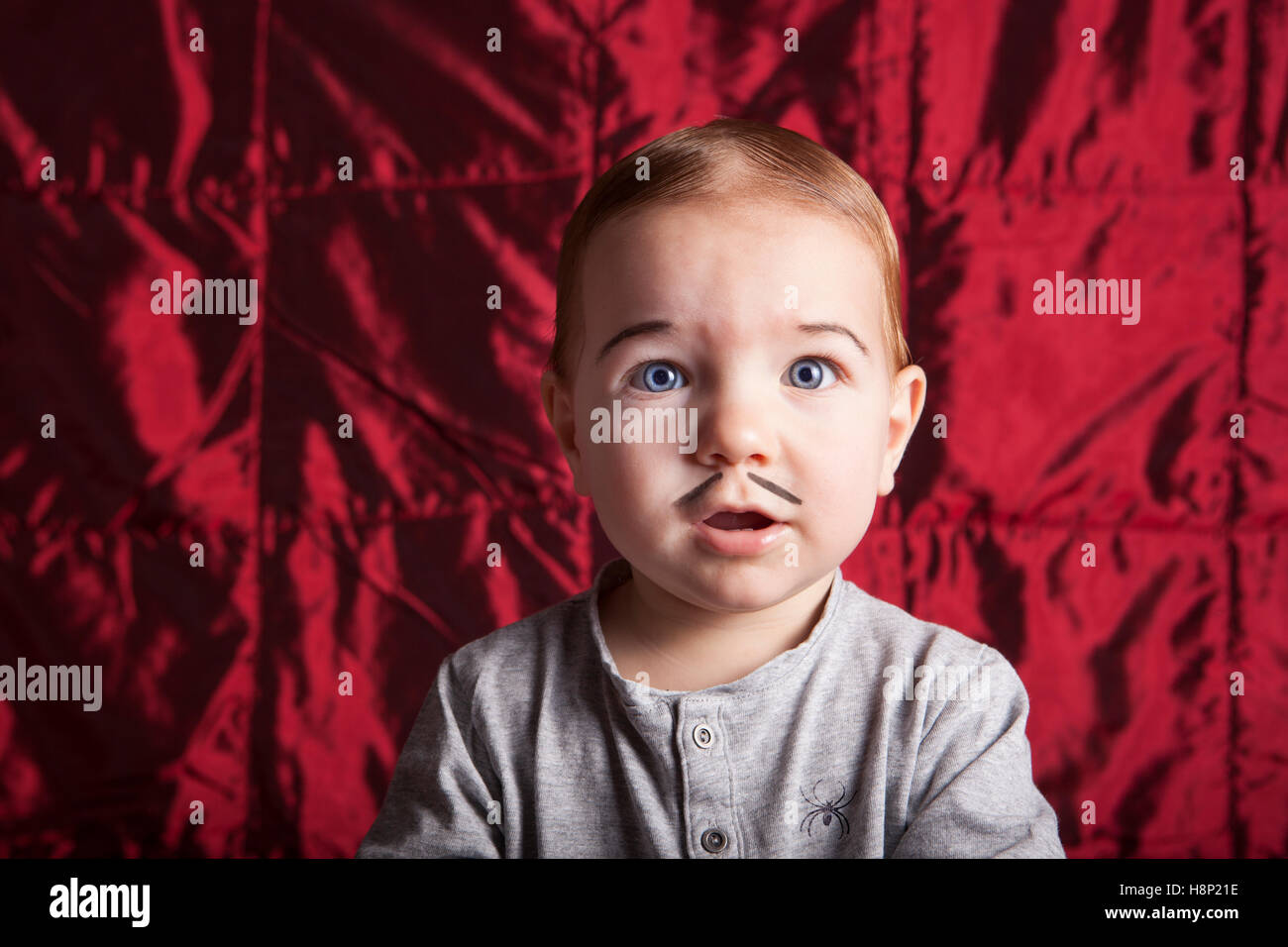 Ritratto di un ragazzino dress up per la festa di Halloween. Raso rosso sfondo Foto Stock