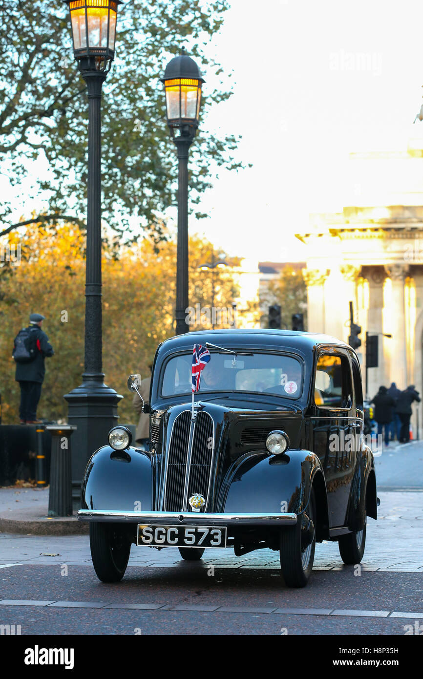 Ritratto di una immagine a colori di un nero 1955 Ford unità popolare attraverso una strada di Londra con union jack flag sul cofano Foto Stock