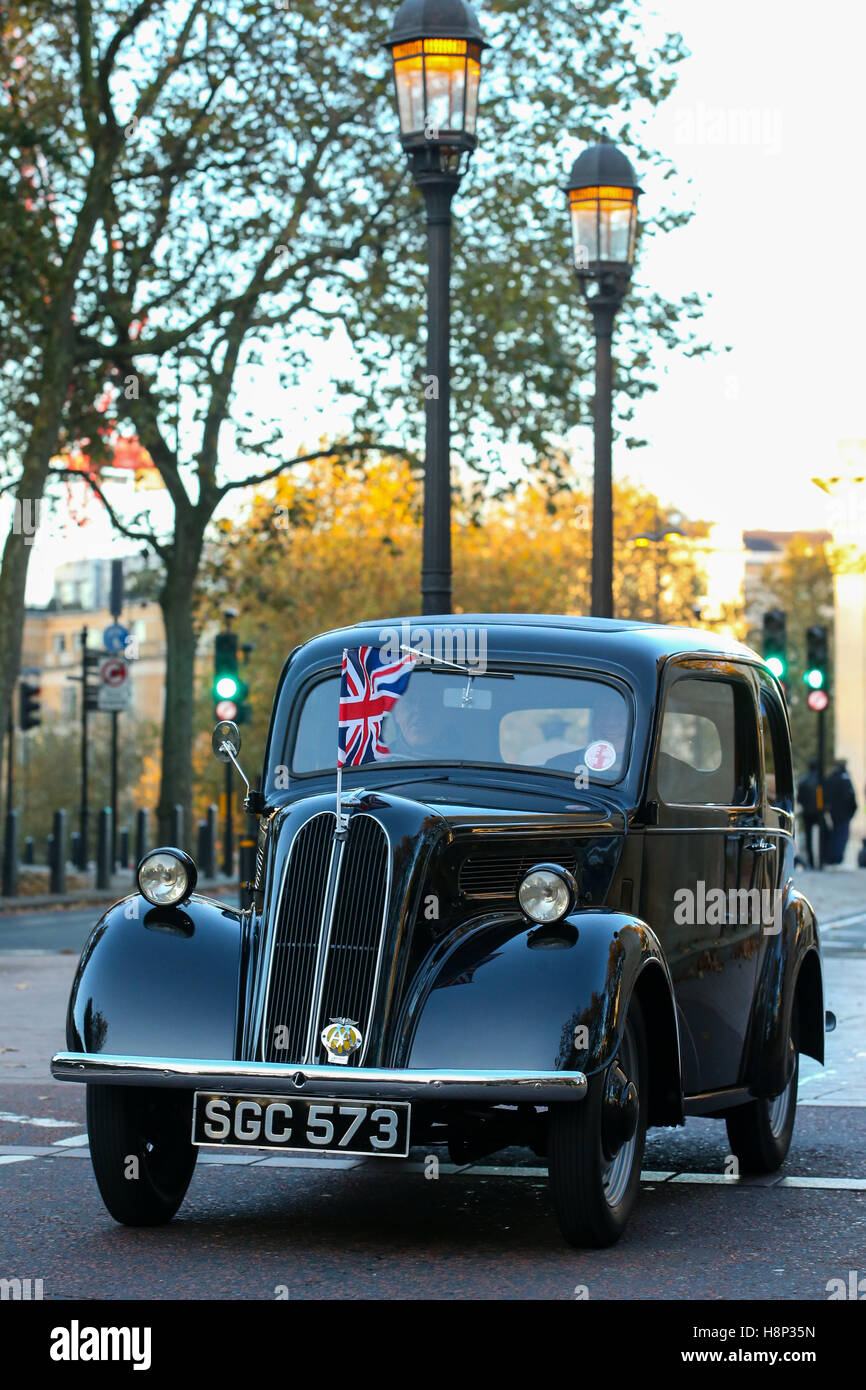 Ritratto di una immagine a colori di un nero 1955 Ford unità popolare attraverso una strada di Londra con union jack flag sul cofano Foto Stock