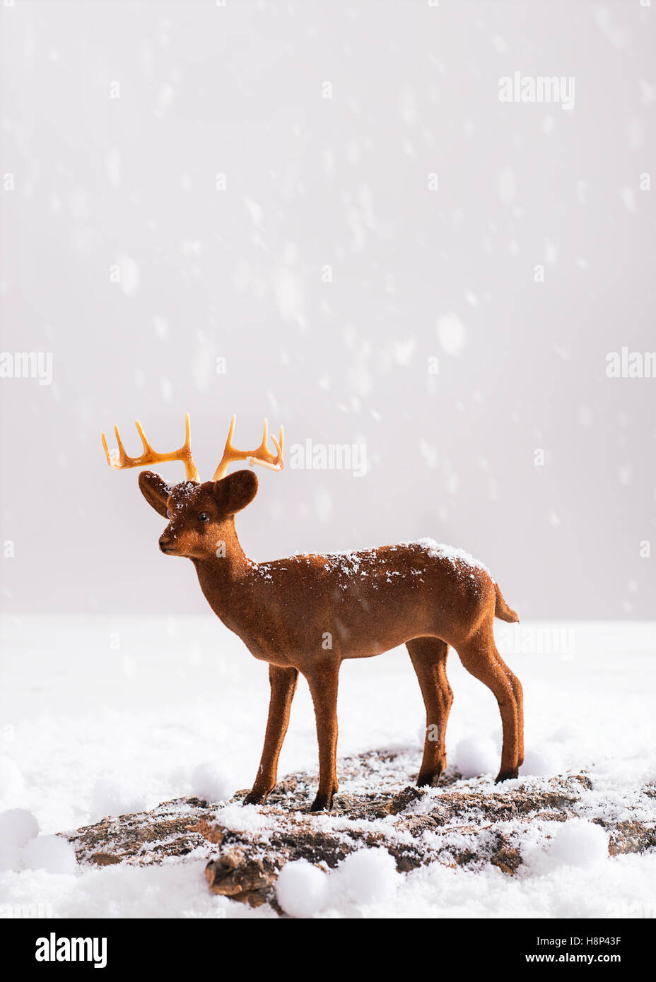 Renne figura degli animali sulla neve log in legno Foto Stock