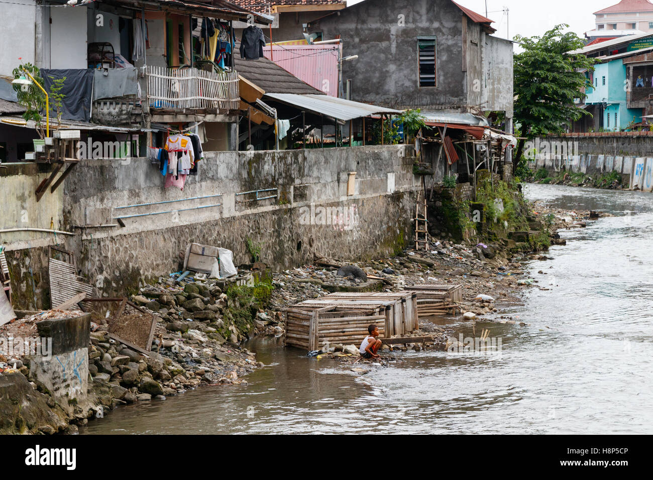 Non identificato ragazzo indonesiano in una delle baraccopoli, lavaggio a Kali banca Codice. La Kali codice è un piccolo fiume che scorre in Yogyakarta, Indonesia. Foto Stock