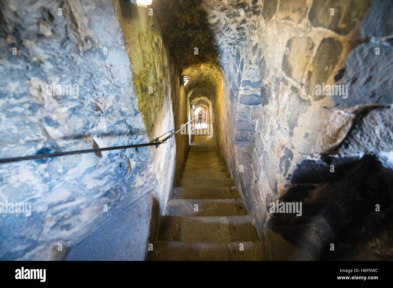 Regno Unito, Inghilterra, Yorkshire, Richmond - un giovane turista femminile in posa sul fondo di una scala all'interno del castello di Richmond, uno dei Foto Stock