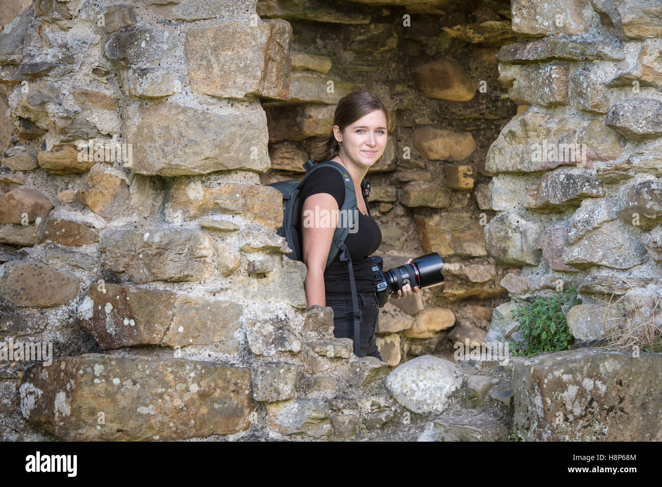 Regno Unito, Inghilterra, Yorkshire, Richmond - un giovane turista femminile con la sua fotocamera all'interno dell'abbazia di Sant'Agata, più comunemente noto come Foto Stock