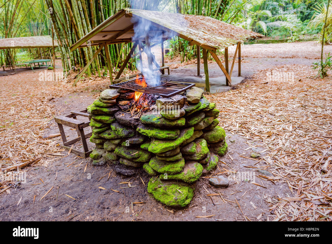 Una buca per il fuoco posto con pietre nella giungla per barbecue esterno camping Foto Stock