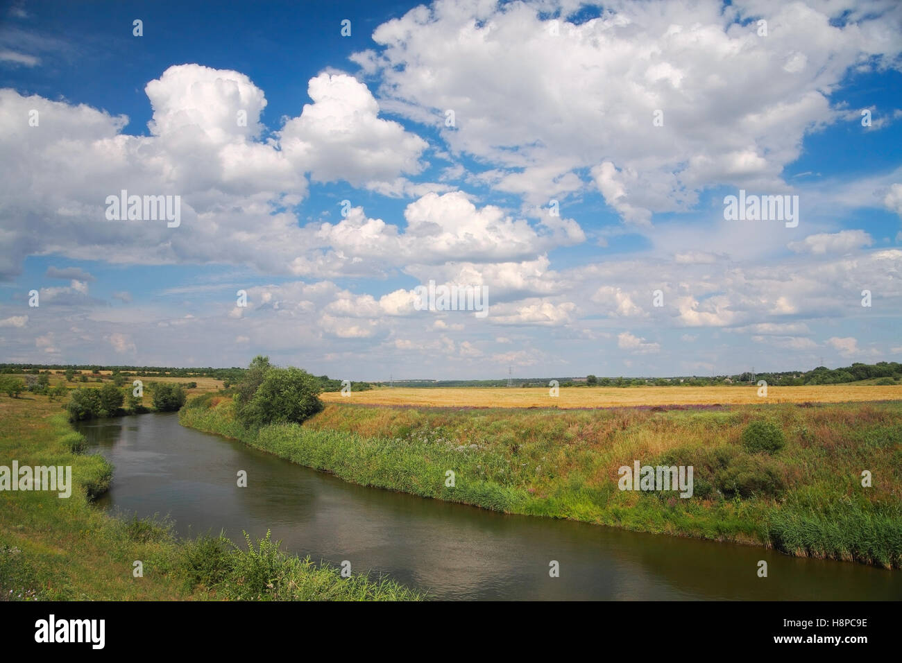 Paesaggio di campagna, river, campo contro il cielo con le nuvole Foto Stock